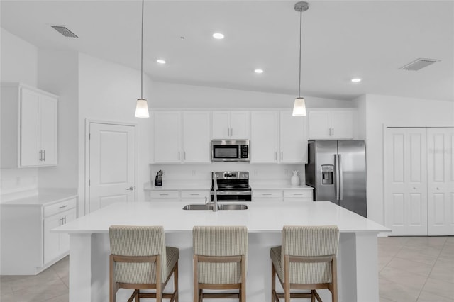 kitchen with an island with sink, lofted ceiling, and appliances with stainless steel finishes