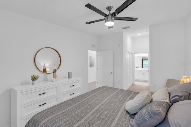 carpeted bedroom featuring ensuite bath and ceiling fan