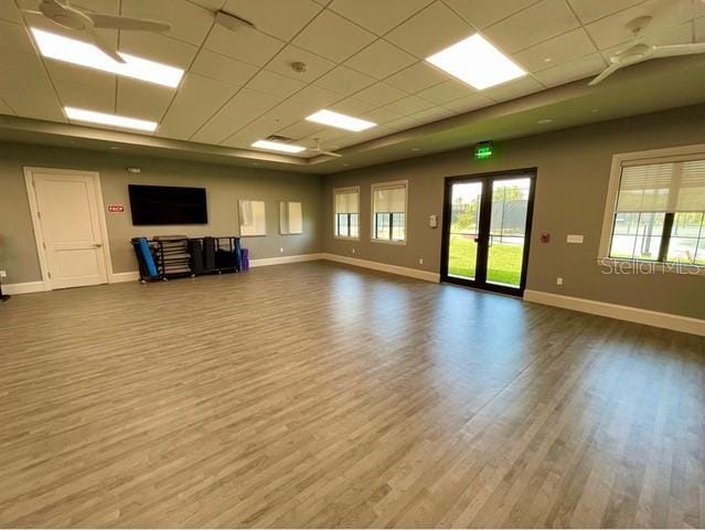 unfurnished living room featuring ceiling fan, hardwood / wood-style flooring, and a paneled ceiling