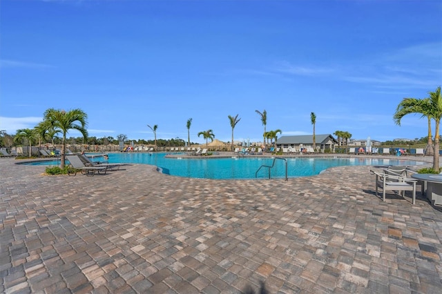 view of pool featuring a patio and central air condition unit