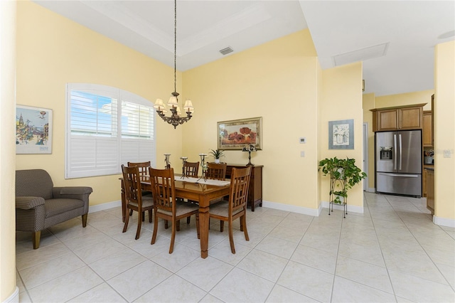 tiled dining space featuring ornamental molding, a notable chandelier, and a tray ceiling