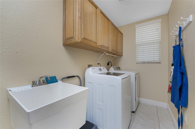 washroom with cabinets, washer and clothes dryer, sink, and light tile patterned floors