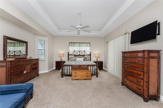 carpeted bedroom featuring a raised ceiling, ceiling fan, and ornamental molding