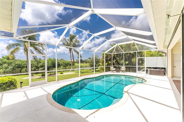 view of pool with glass enclosure and a patio