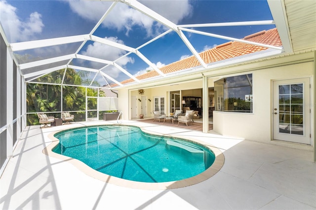 view of pool featuring glass enclosure, ceiling fan, and a patio