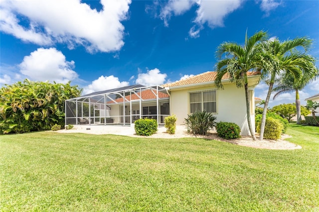 back of house featuring a lawn and a lanai