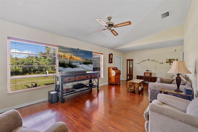 living room with dark wood-type flooring, ceiling fan, a wealth of natural light, and vaulted ceiling