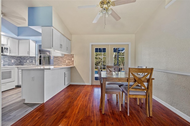 dining room featuring dark wood-type flooring, ceiling fan, sink, and french doors