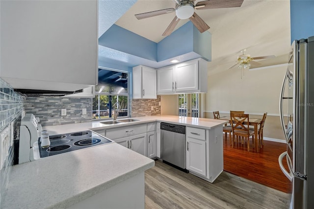 kitchen featuring stainless steel appliances, kitchen peninsula, sink, ceiling fan, and white cabinets