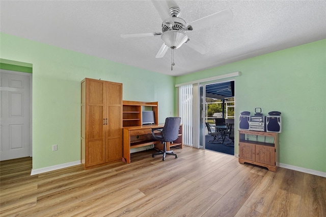 office area with light wood-type flooring, a textured ceiling, and ceiling fan