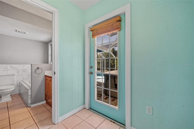 entryway featuring tile walls and light tile patterned flooring