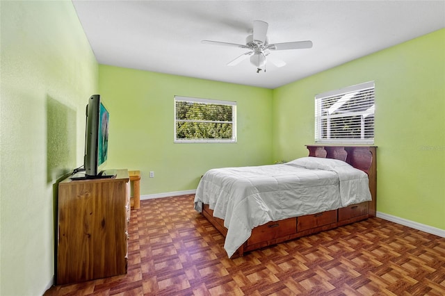 bedroom with dark parquet floors and ceiling fan