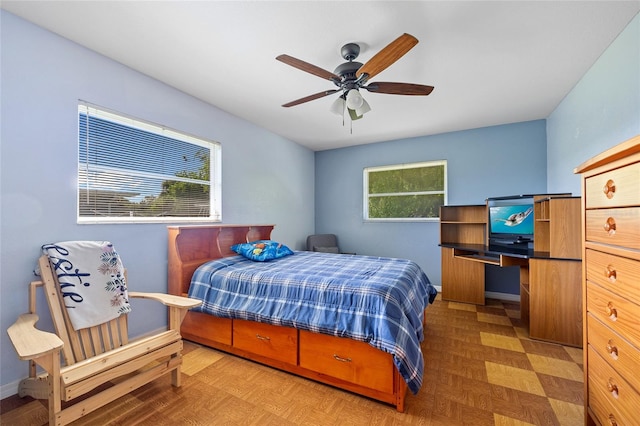 bedroom with parquet floors, ceiling fan, and multiple windows