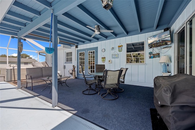 view of patio featuring area for grilling, ceiling fan, and glass enclosure