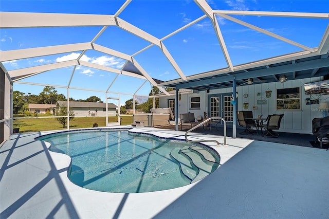 view of swimming pool with a yard, a lanai, a patio area, and french doors