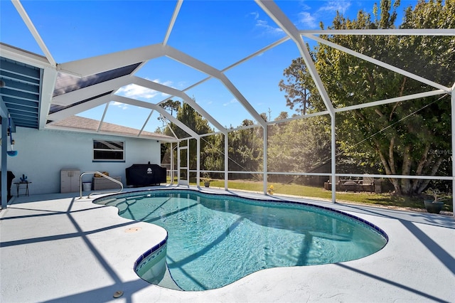 view of pool with glass enclosure and a patio