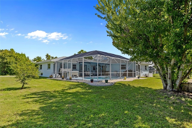 back of house with glass enclosure and a yard