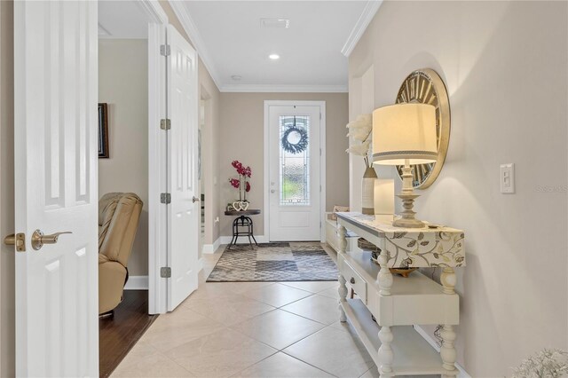 tiled entrance foyer featuring crown molding