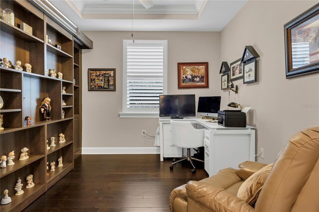 office area with dark wood-type flooring, a raised ceiling, and ornamental molding