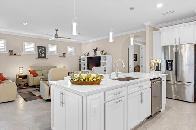 kitchen featuring an island with sink, sink, ceiling fan, high quality fridge, and white cabinets