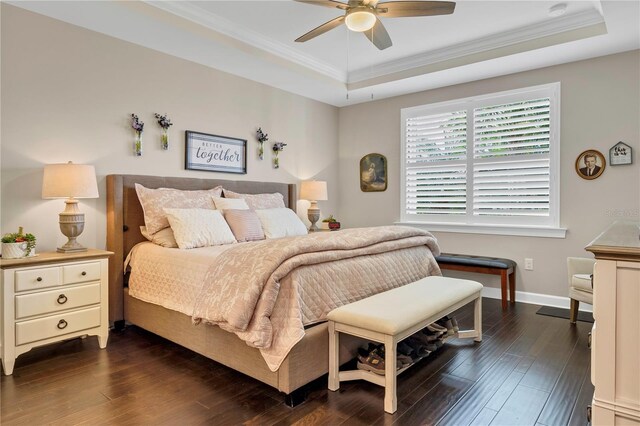 bedroom with ornamental molding, dark wood-type flooring, ceiling fan, and a raised ceiling