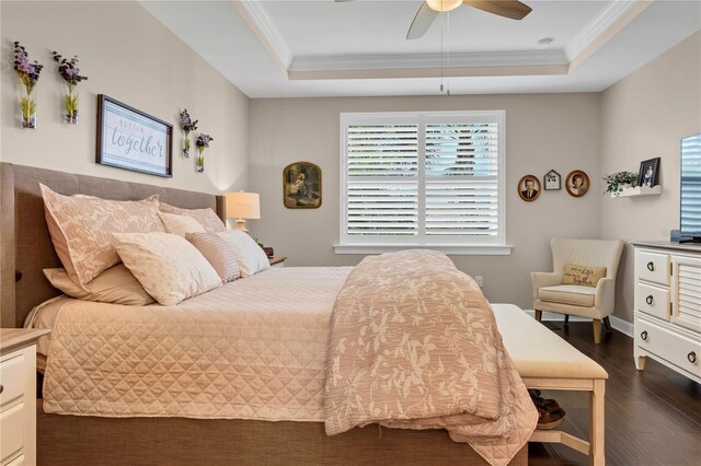 bedroom with a tray ceiling, ceiling fan, dark hardwood / wood-style flooring, and crown molding