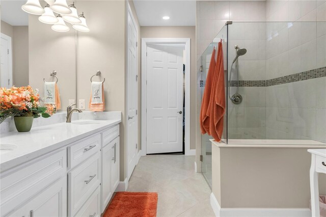 bathroom with vanity, a tile shower, and tile patterned floors