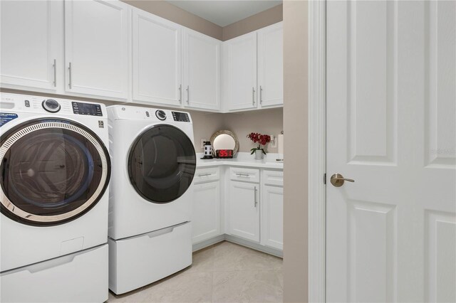 clothes washing area featuring washing machine and dryer, cabinets, and light tile patterned flooring