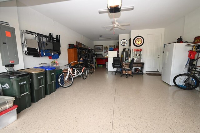 garage with white refrigerator, a garage door opener, electric panel, and ceiling fan