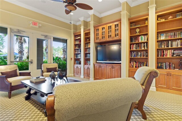 carpeted living room featuring ceiling fan, plenty of natural light, decorative columns, and crown molding