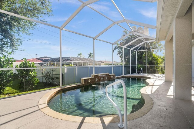 view of pool featuring pool water feature, a patio, and a lanai