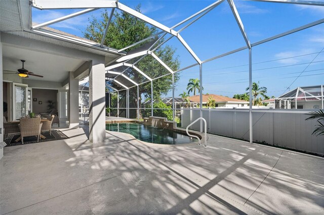 view of pool with glass enclosure, ceiling fan, and a patio