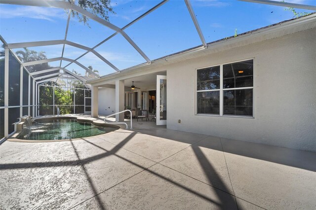 view of swimming pool featuring a lanai, a jacuzzi, ceiling fan, and a patio