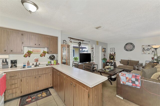 kitchen featuring a textured ceiling, kitchen peninsula, and sink