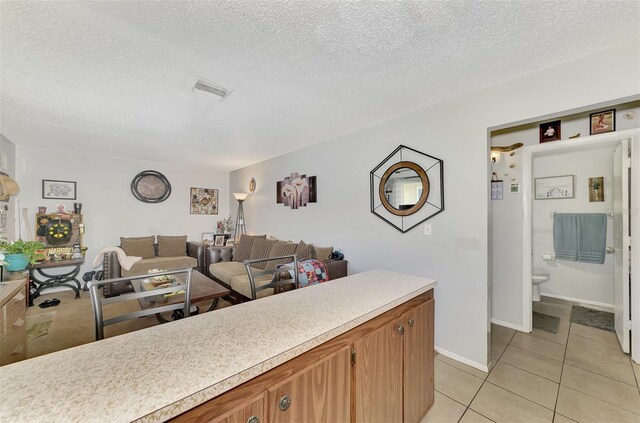 kitchen with a textured ceiling and light tile patterned flooring