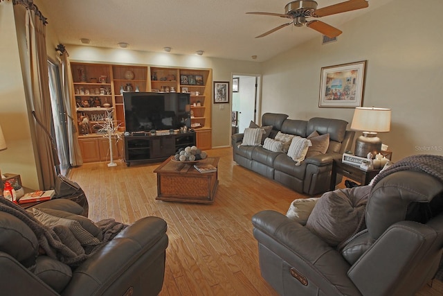 living room featuring lofted ceiling, ceiling fan, and light hardwood / wood-style flooring