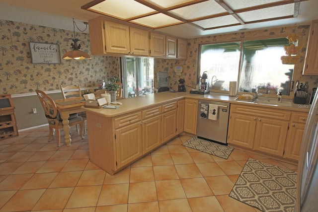 kitchen with stainless steel dishwasher, kitchen peninsula, sink, and light tile patterned floors