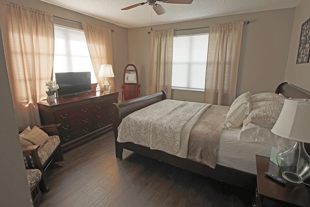 bedroom with a textured ceiling, ceiling fan, and dark hardwood / wood-style floors