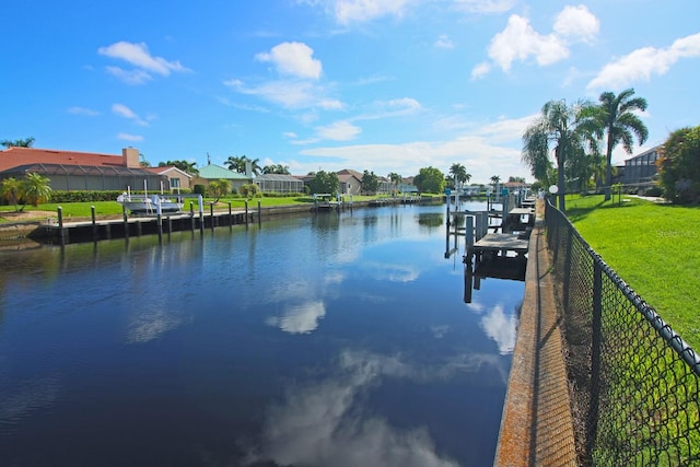 view of dock with a water view and a yard