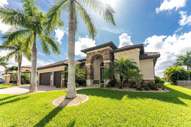 mediterranean / spanish home with a front lawn and a garage