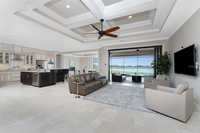 living room with a tray ceiling, beamed ceiling, coffered ceiling, crown molding, and ceiling fan