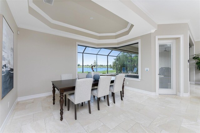 dining room featuring crown molding, a water view, and a raised ceiling