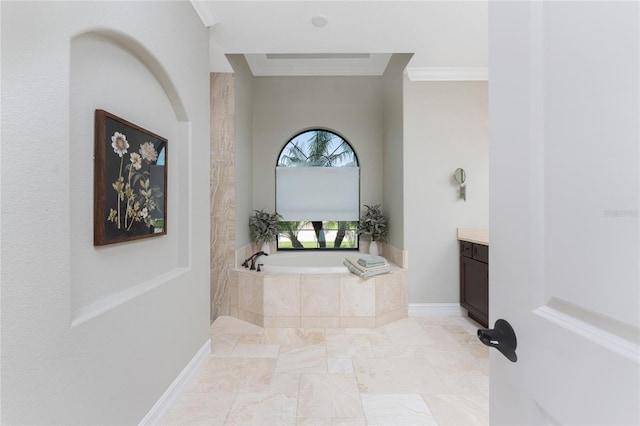 bathroom featuring ornamental molding, tiled tub, and vanity