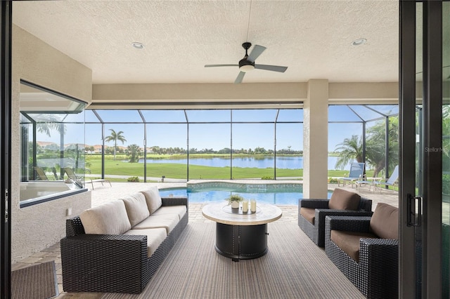 sunroom / solarium with a water view and ceiling fan