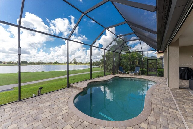 view of pool with a lanai, a water view, and a patio area