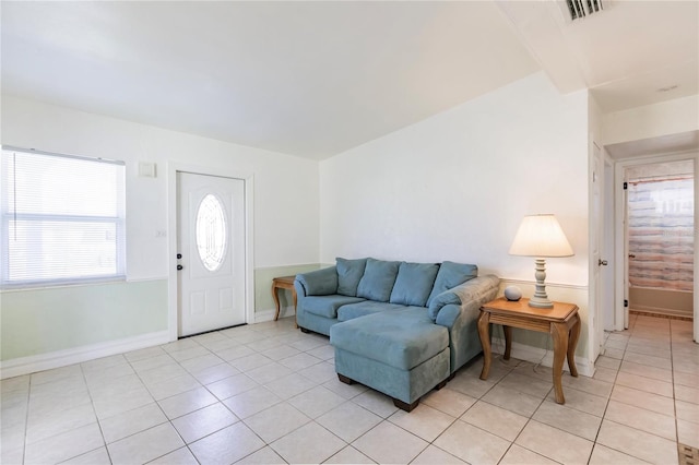 living room with light tile patterned flooring and vaulted ceiling with beams