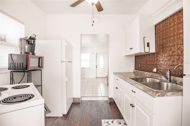 kitchen with decorative backsplash, white cabinets, dark hardwood / wood-style flooring, sink, and white appliances