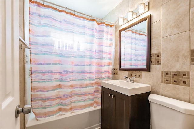 full bathroom featuring vanity, toilet, and tile walls