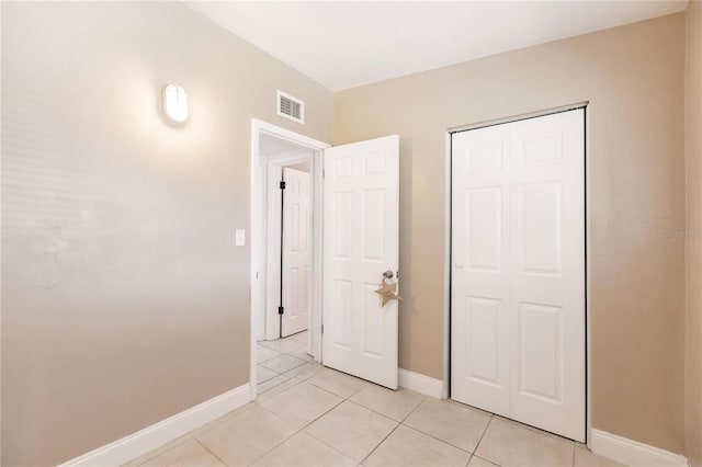 unfurnished bedroom featuring a closet and light tile patterned flooring