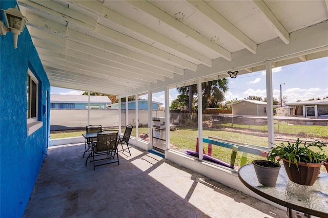 sunroom featuring beamed ceiling